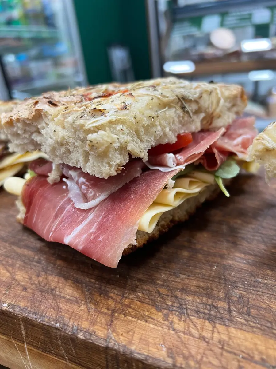 Sándwich de jamón crudo, queso, tomate y hojas verdes