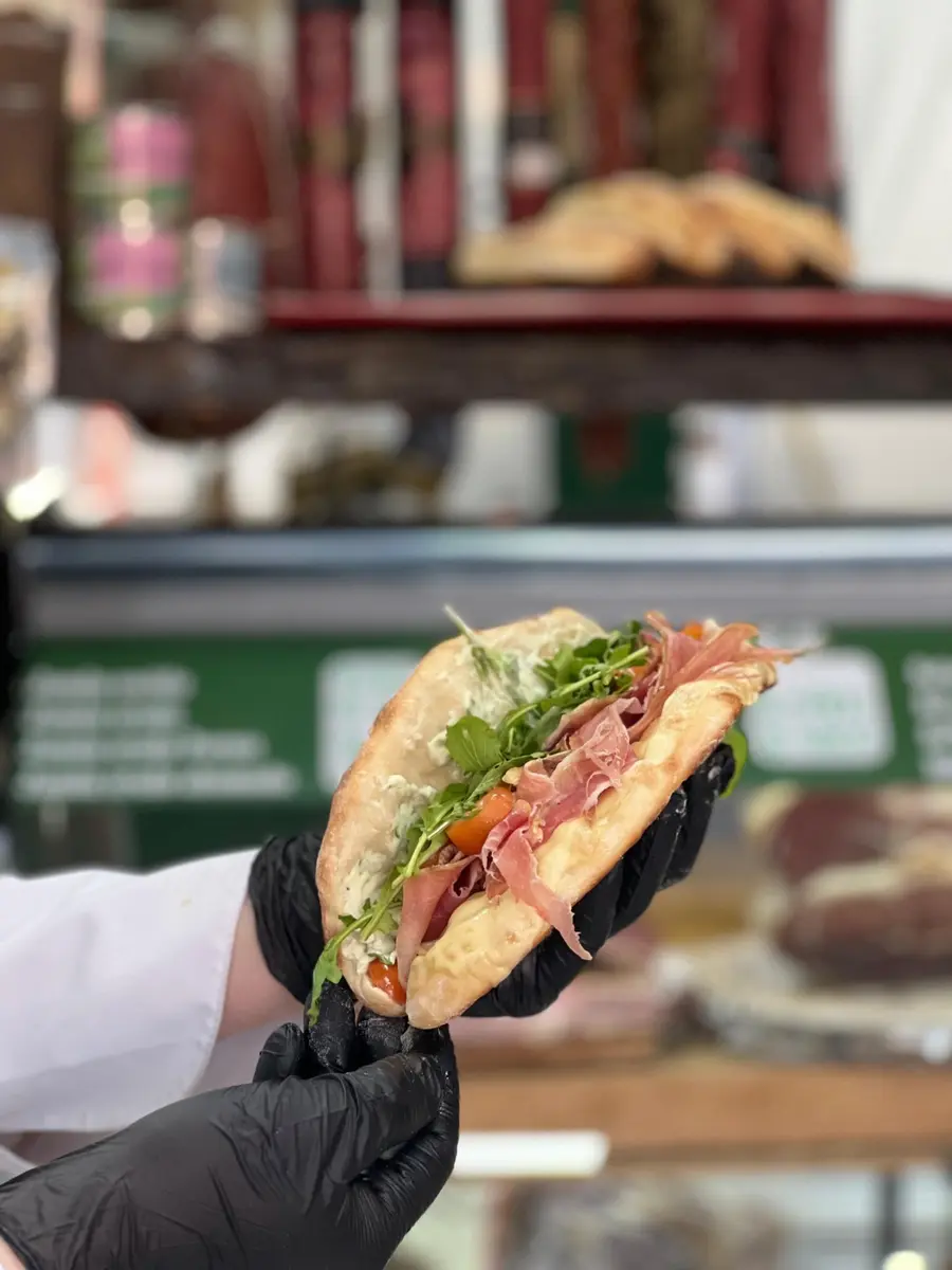 Sándwich recién preparado sostenido frente al mostrador